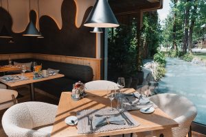 Ein hübsch gedeckter Tisch für zwei Personen. Die Sonne scheint in den Raum.