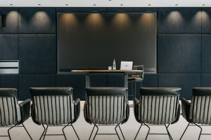 moderner Präsentationsraum, großer Screen im Hintergrund, Rednerpult